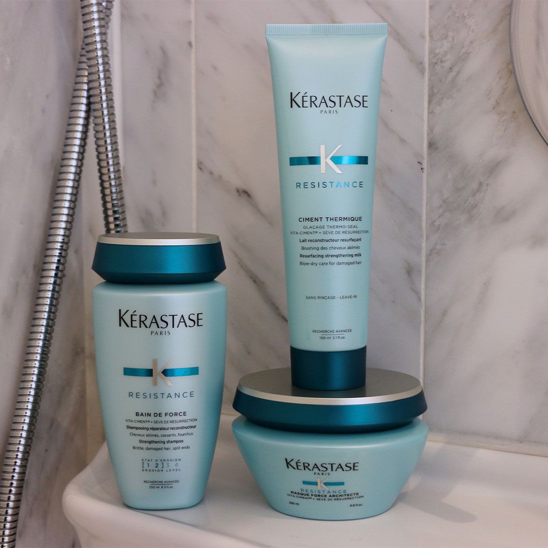 Three bottles of Kérastase hair products on a sink