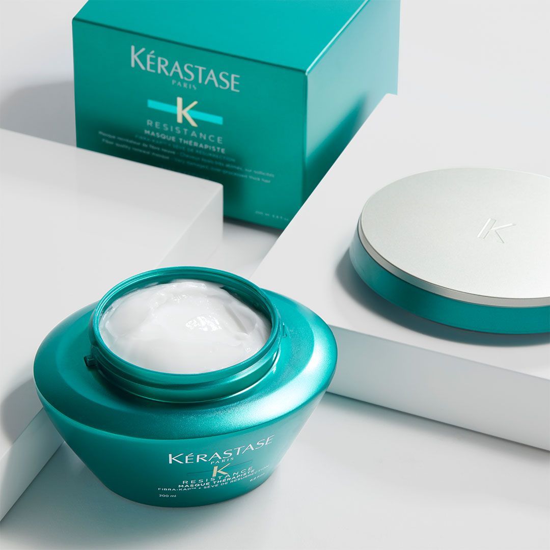 A jar of Kérastase creme is sitting next to a box