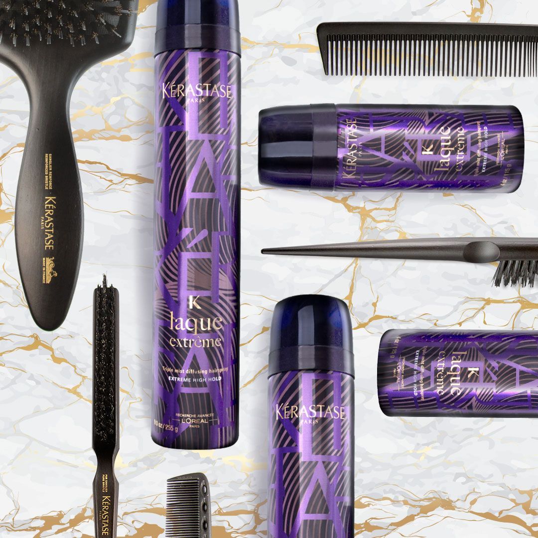 A bunch of purple bottles and brushes on a marble surface