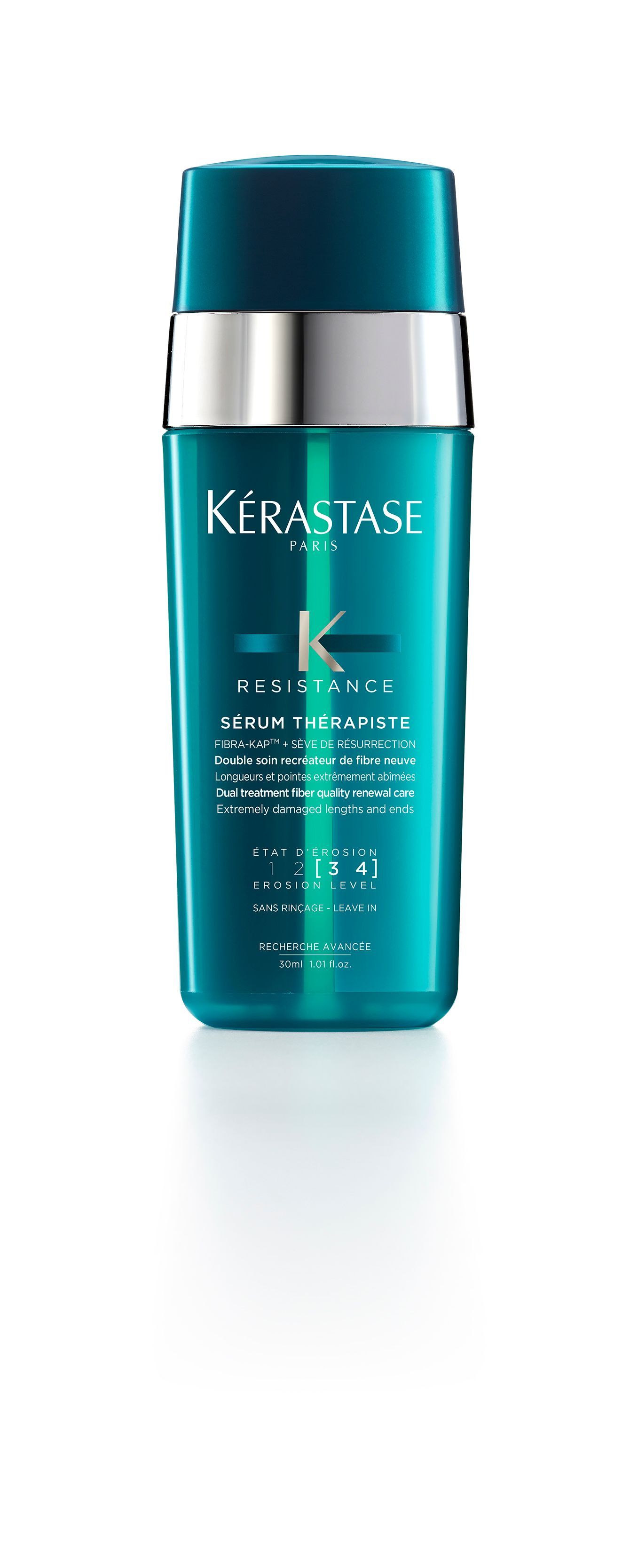 A bottle of Kérastase hair product is sitting on a white surface