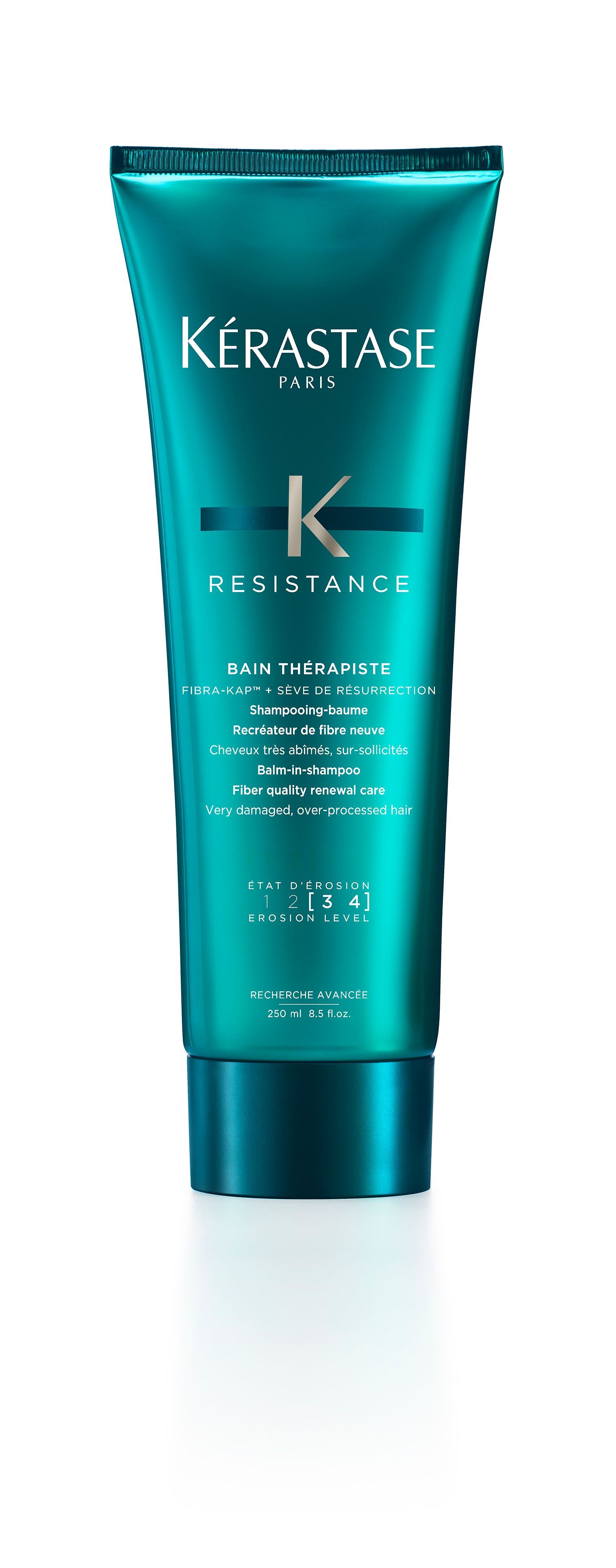 A bottle of Kérastase hair product is sitting on a white surface