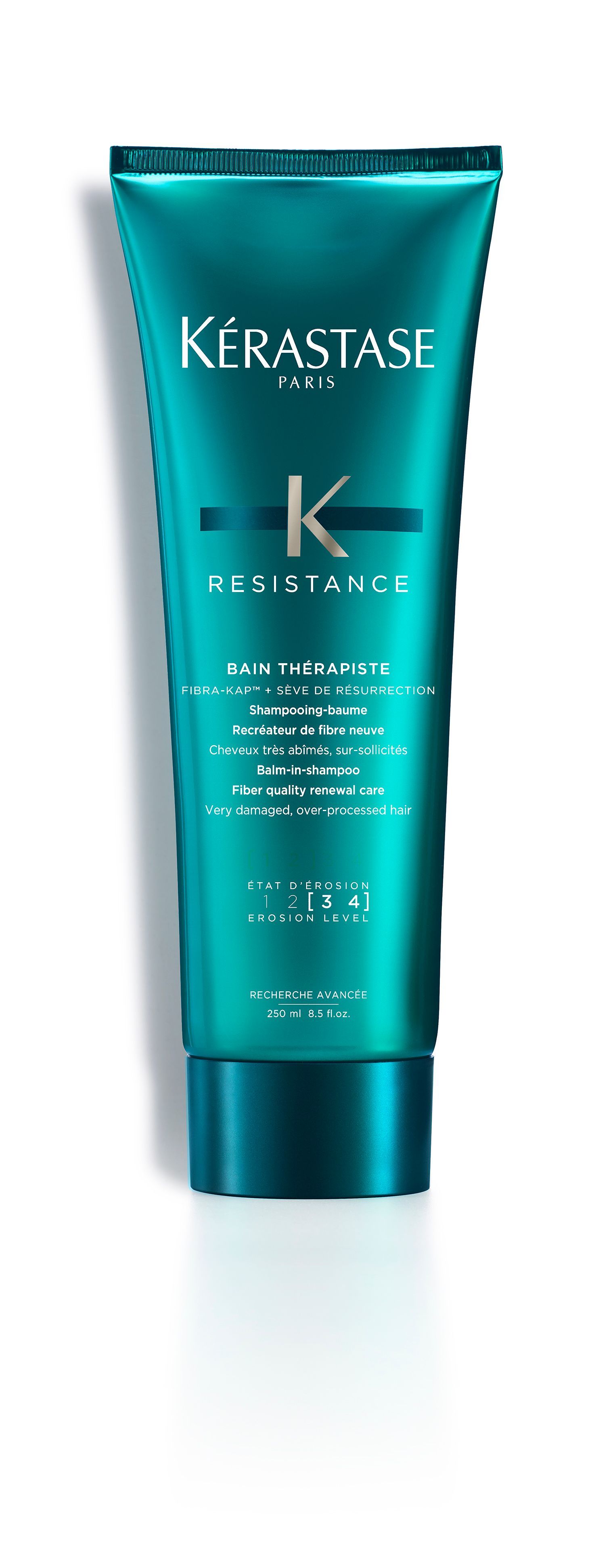 A bottle of Kérastase hair product is sitting on a white surface