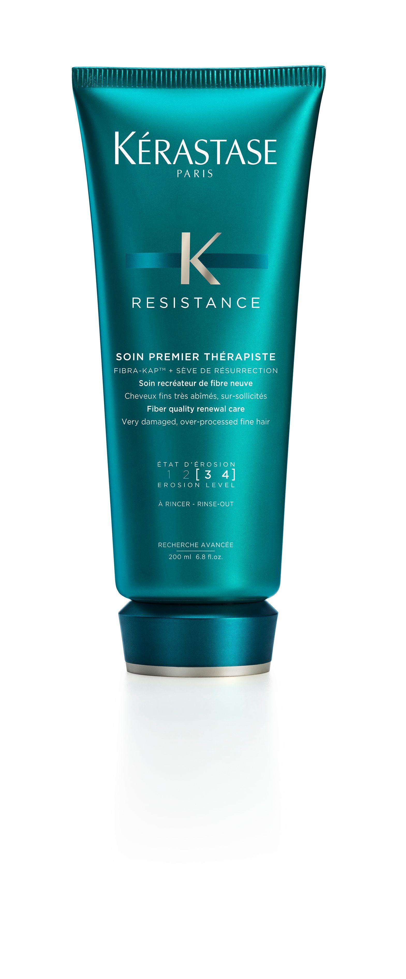 A bottle of Kérastase hair product on a white background