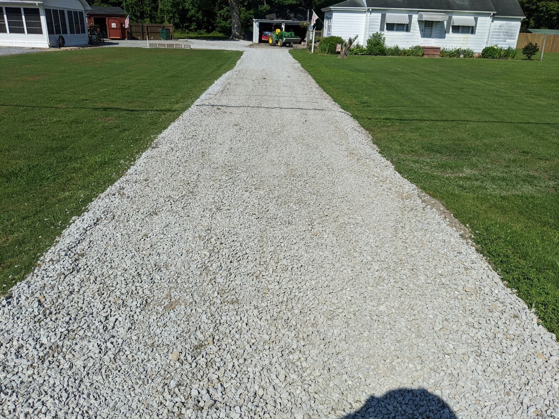 Gravel path leading to houses across a green lawn on a sunny day