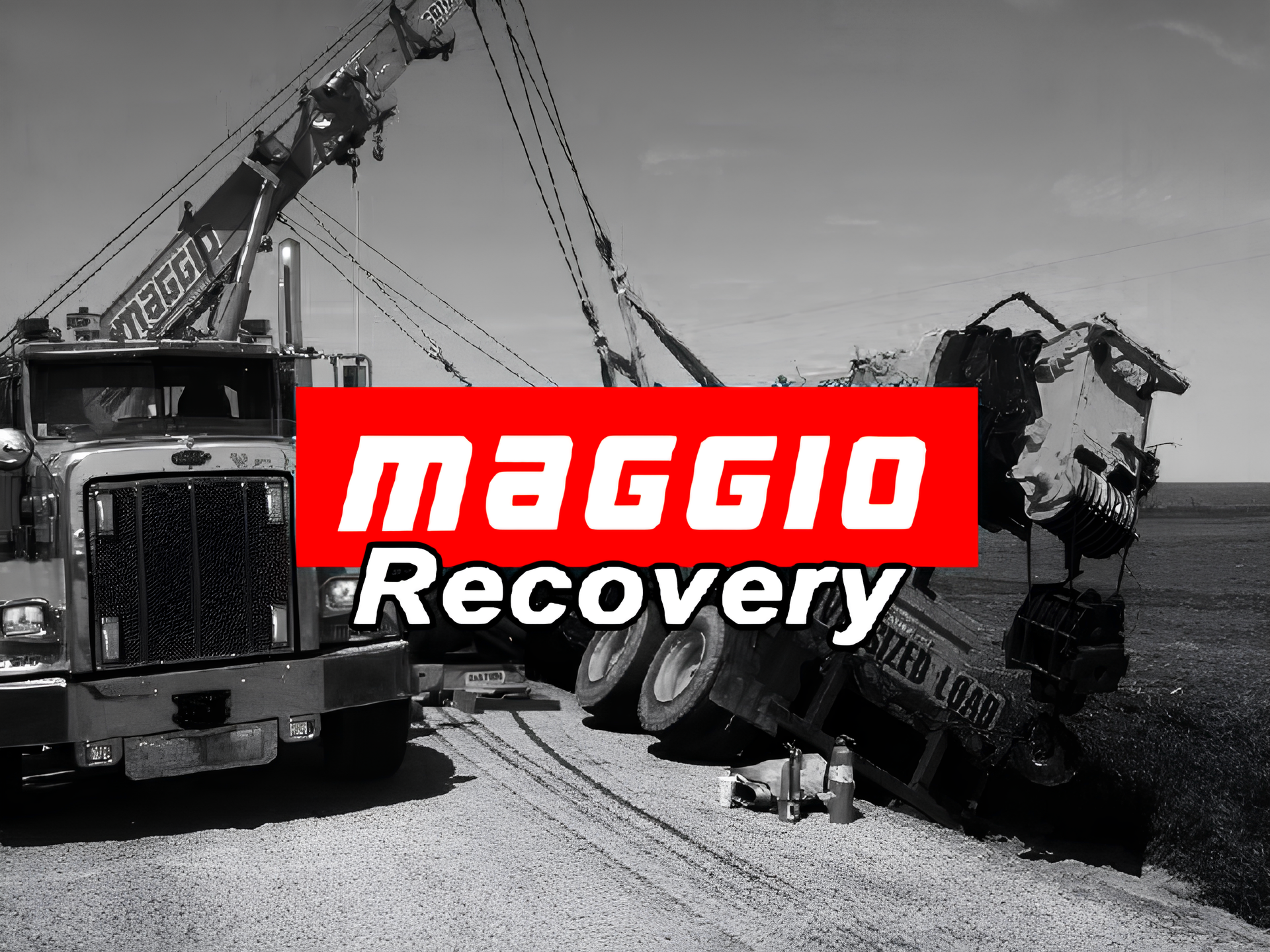 Tow truck recovering a semi-truck that is on its side. Red 