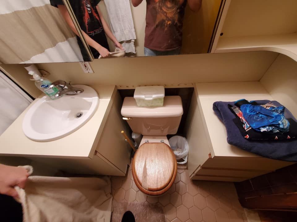 A bathroom with a toilet a sink and a mirror
