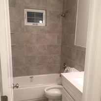 A bathroom with a toilet , sink , tub and shower.