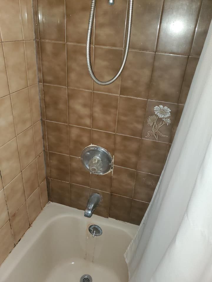 A bathroom with a bathtub and a shower.