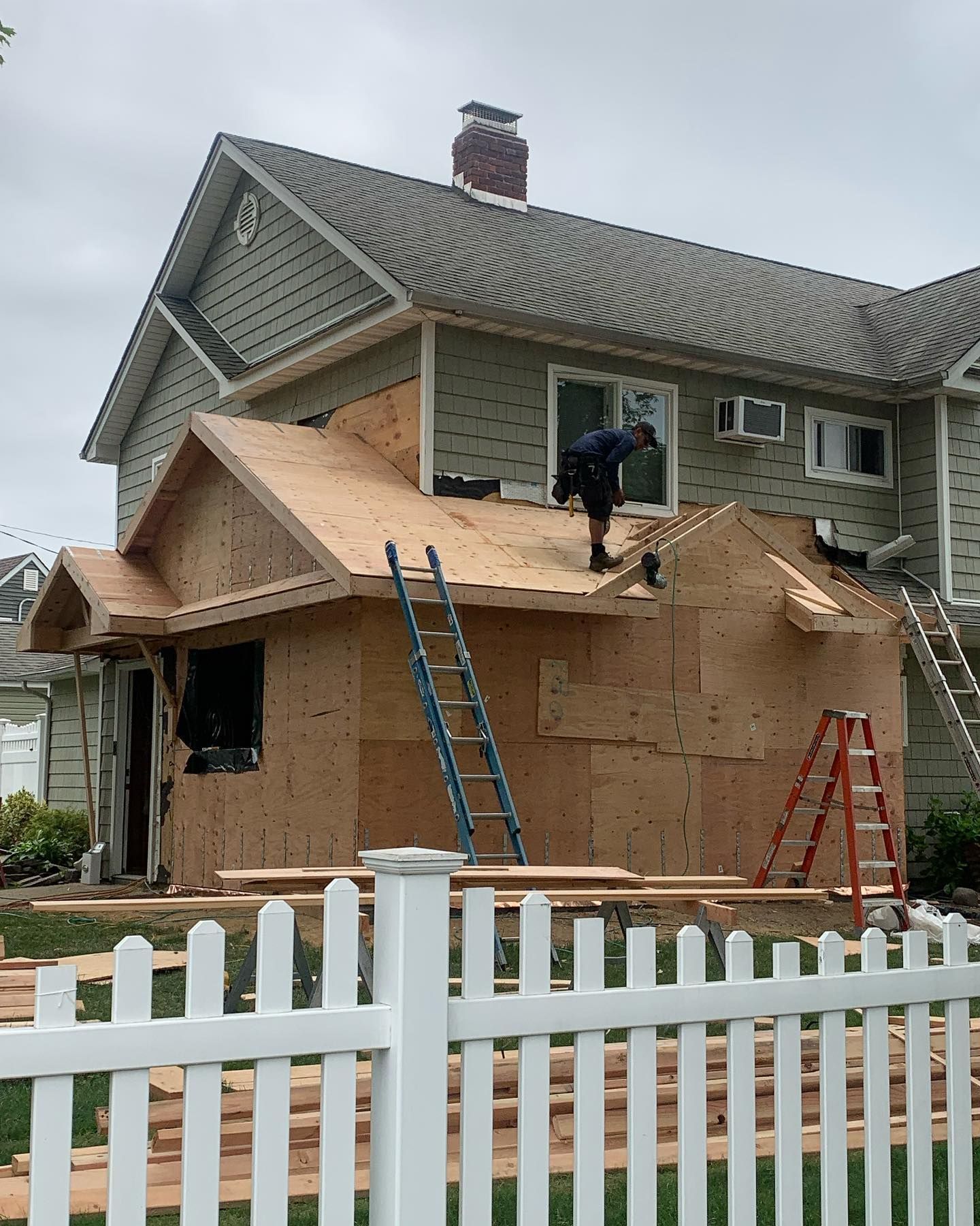 A man is working on the roof of a house