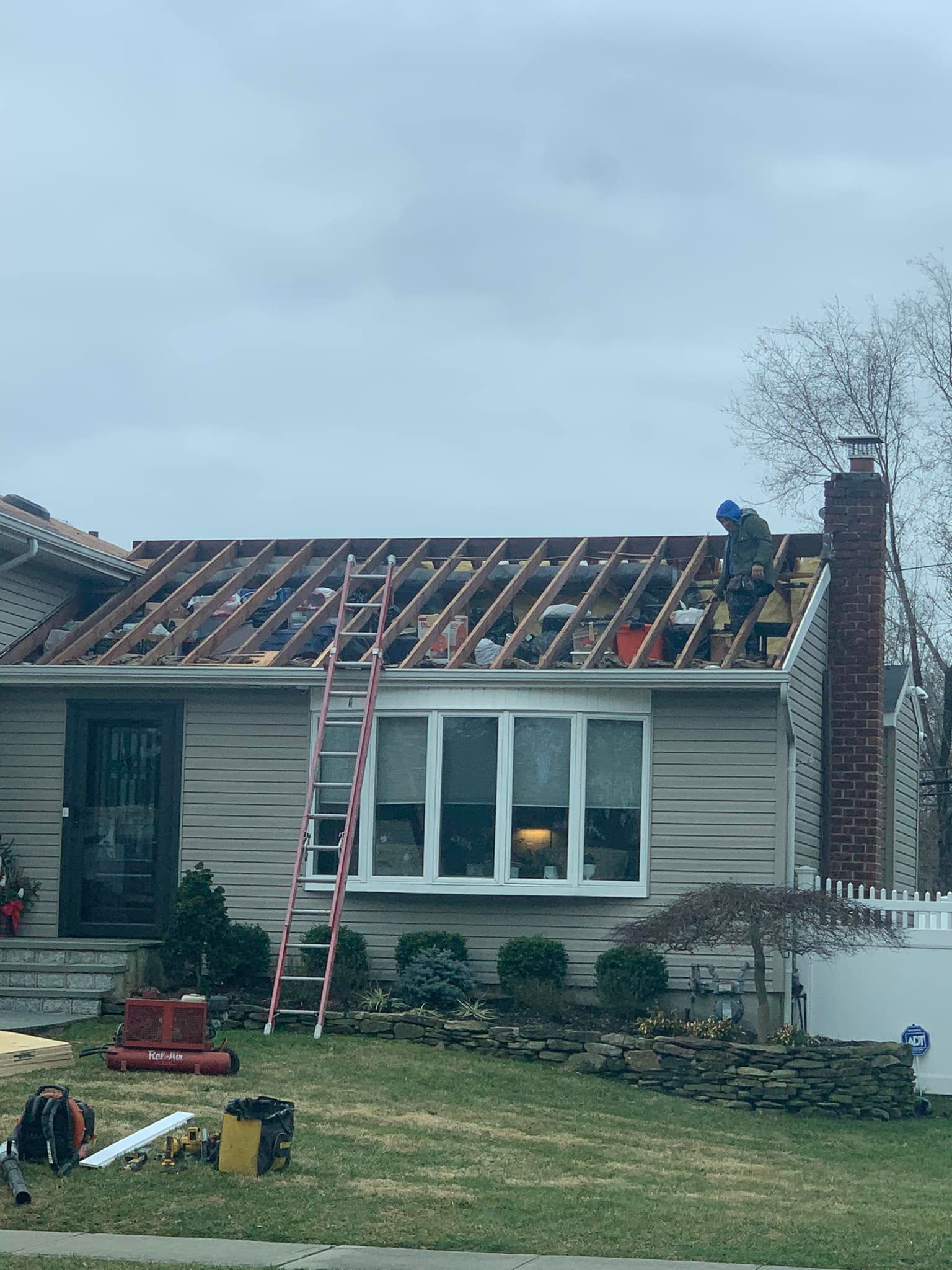 A house is being remodeled with a roof being installed.