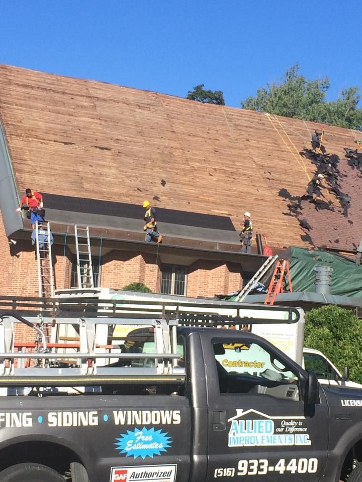A truck that says roofing siding windows is parked in front of a house
