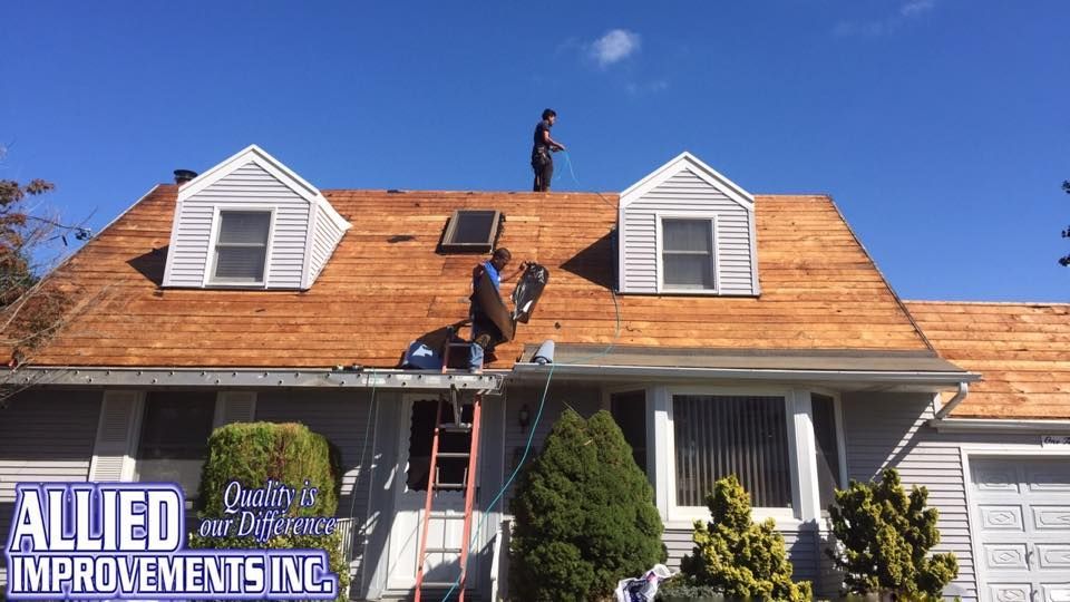 Two men are working on the roof of a house.