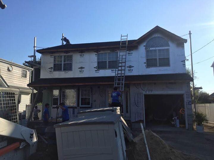 A house is being remodeled with a ladder on the roof.