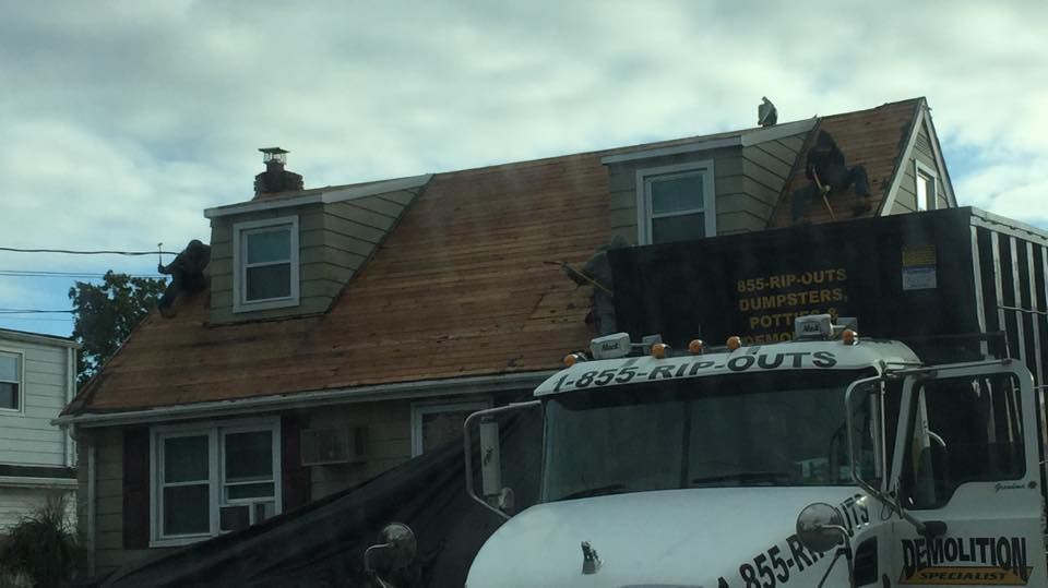 A white revolution truck is parked in front of a house