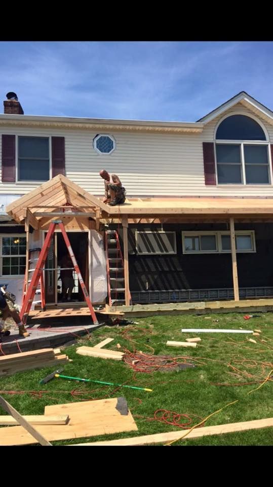 A man is sitting on the roof of a house.