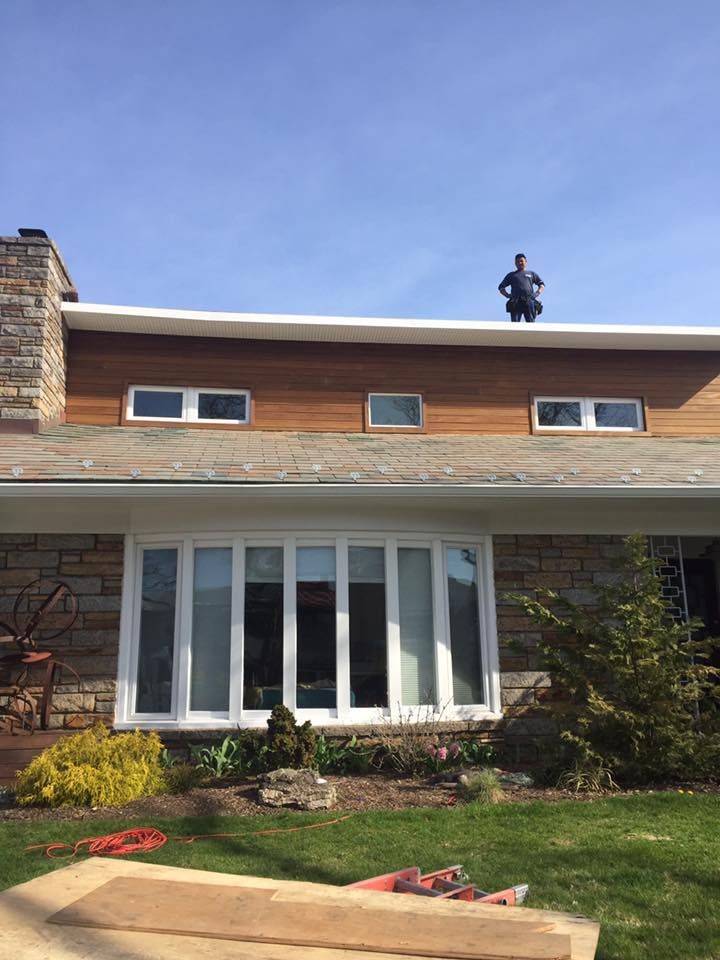 A man is standing on the roof of a house.