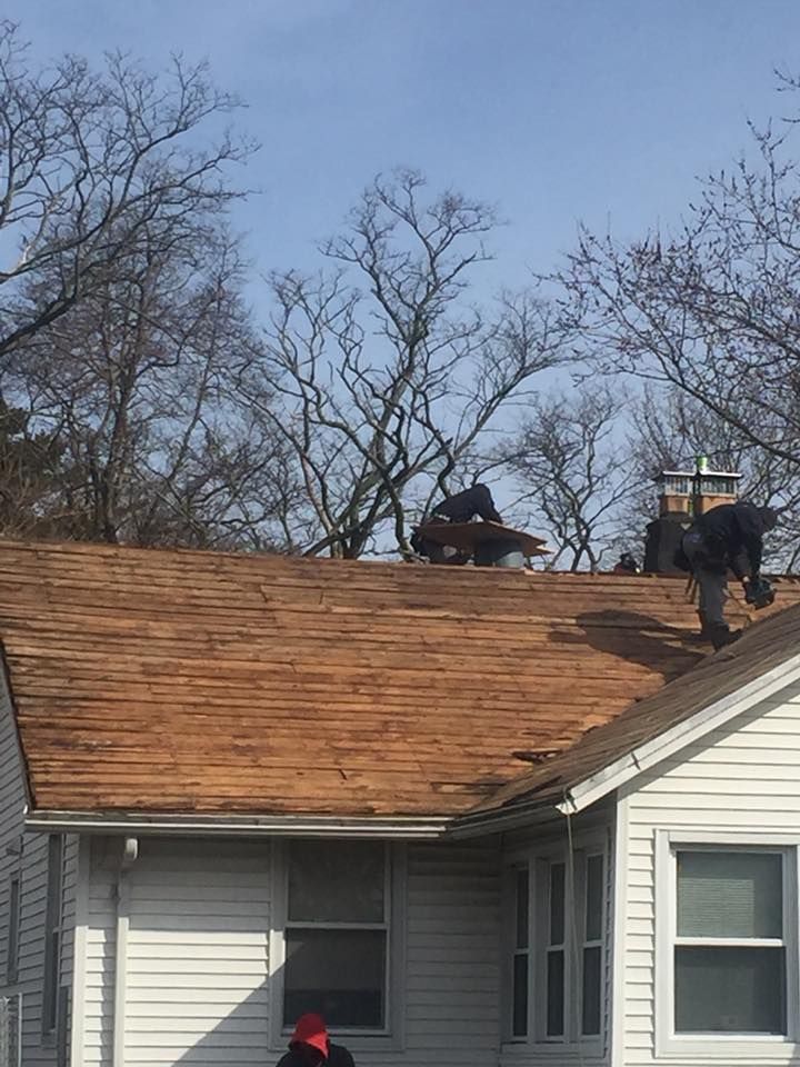 Two men are working on the roof of a house.