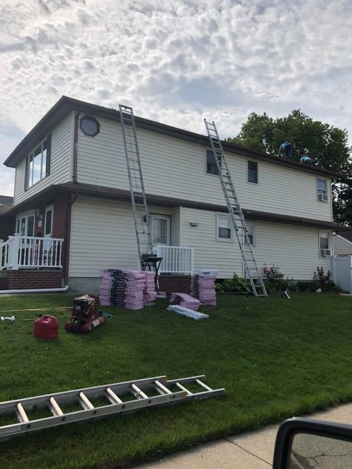 A house is being painted with a ladder in front of it.