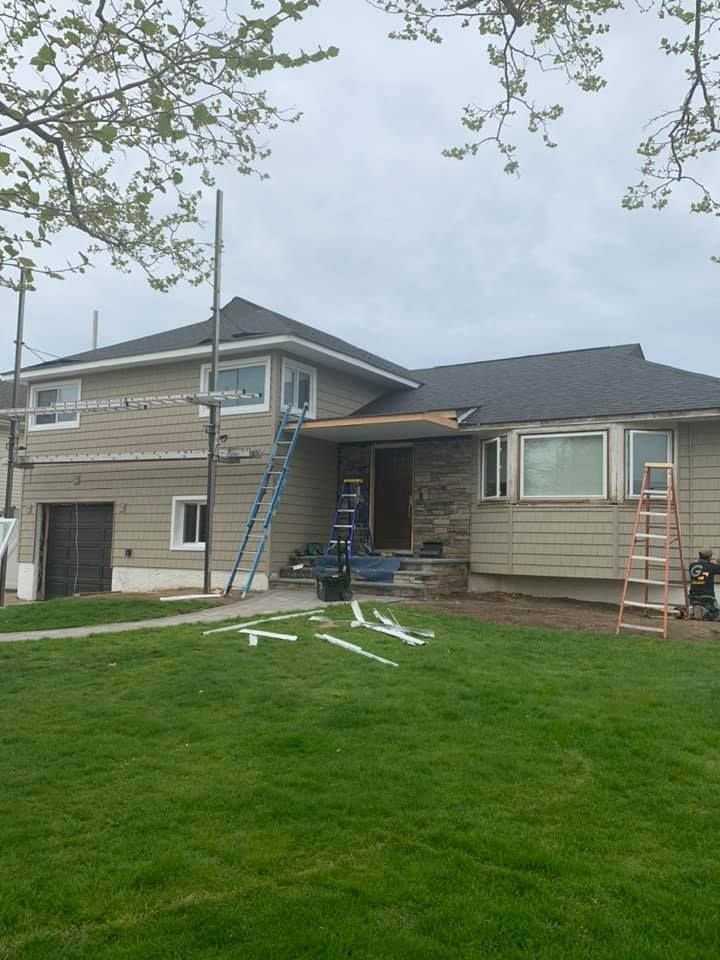 A house is being painted with a ladder in front of it.