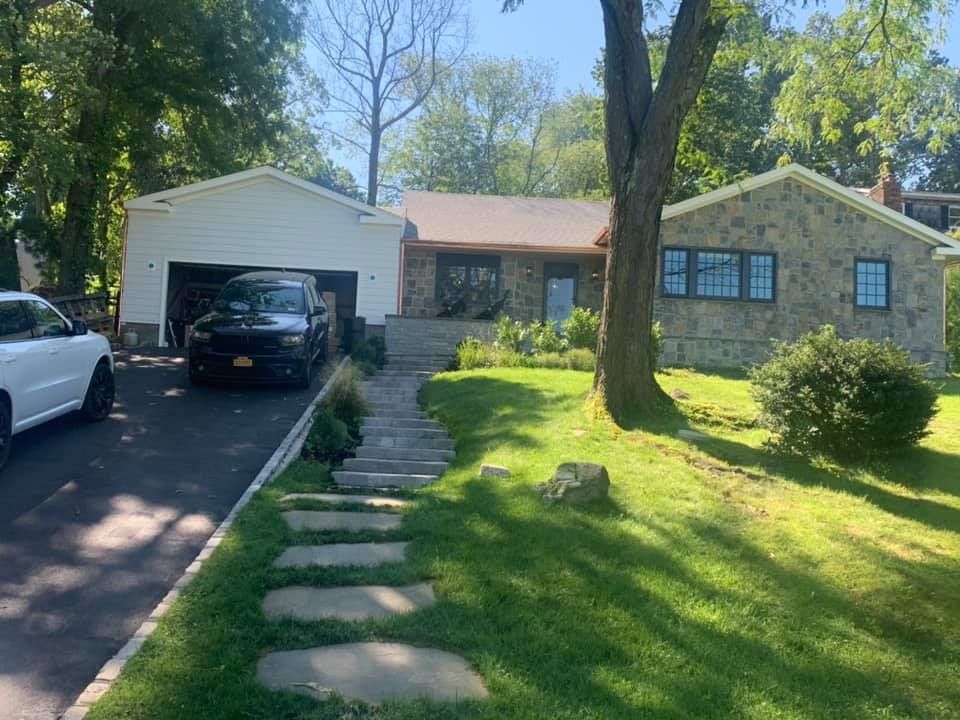 A car is parked in the driveway of a house.