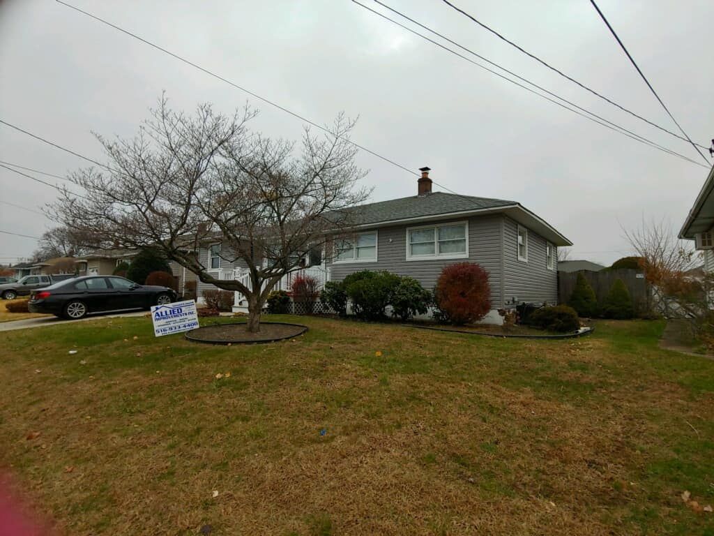 A house with a for sale sign in front of it