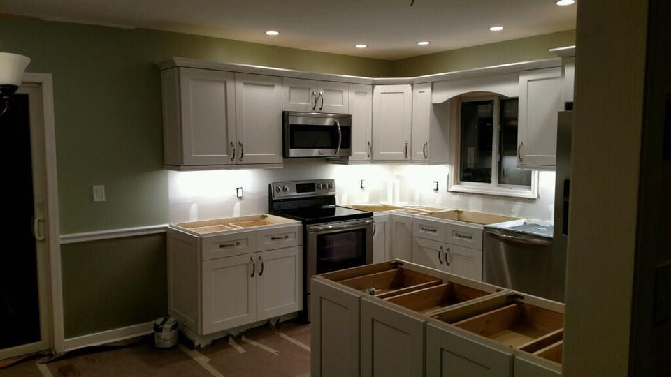 A kitchen with white cabinets and stainless steel appliances is being remodeled.