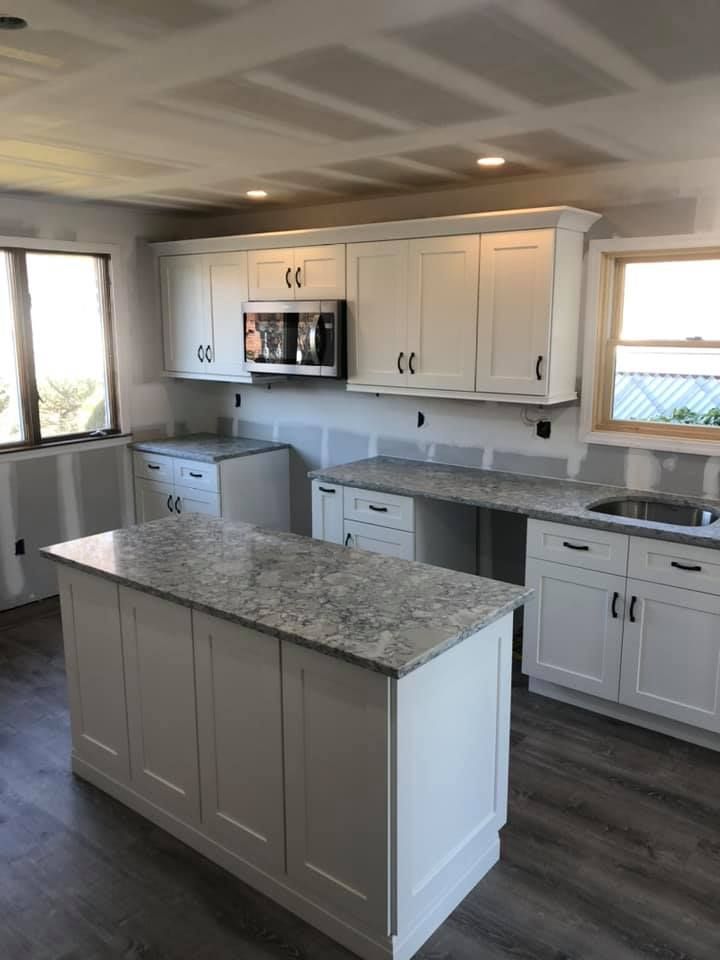A kitchen with white cabinets and granite counter tops