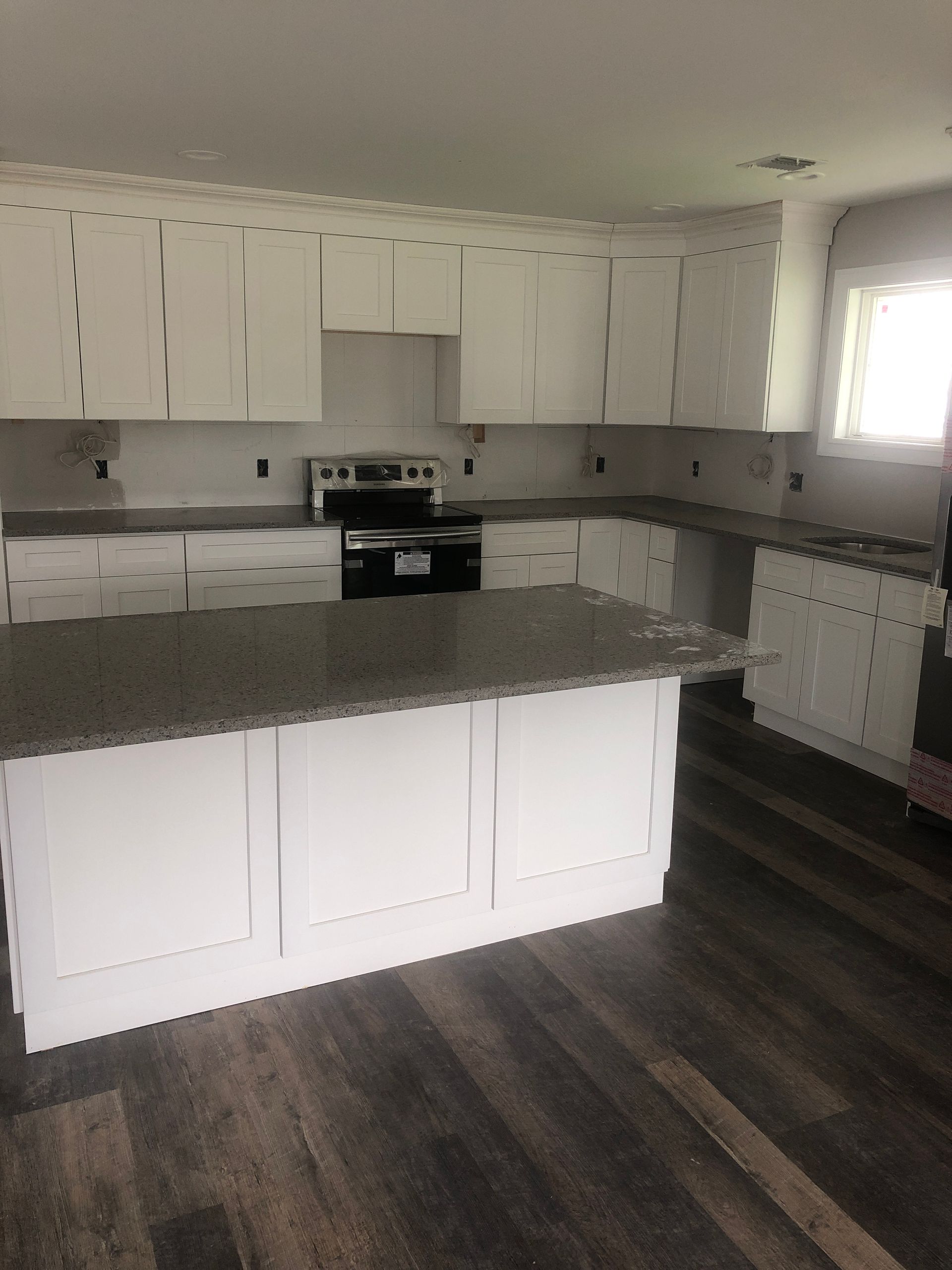 A kitchen with white cabinets and granite counter tops