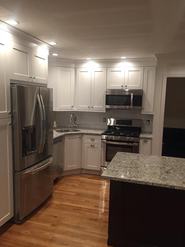 A kitchen with stainless steel appliances and white cabinets