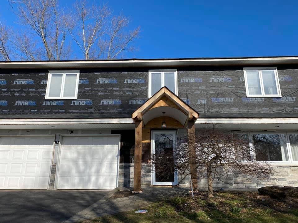 The front of a house with a porch and a garage.