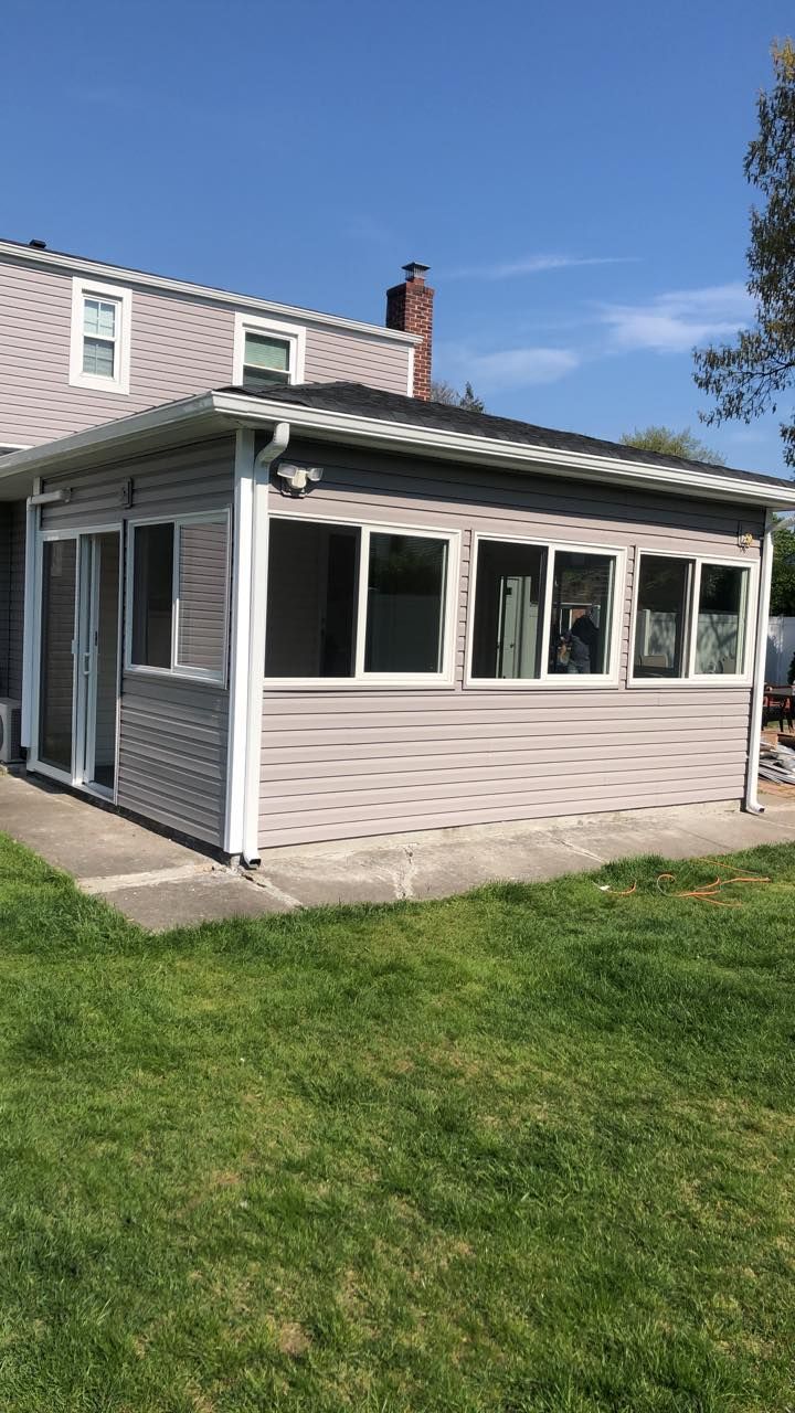 A house with a screened in porch and a lot of windows.