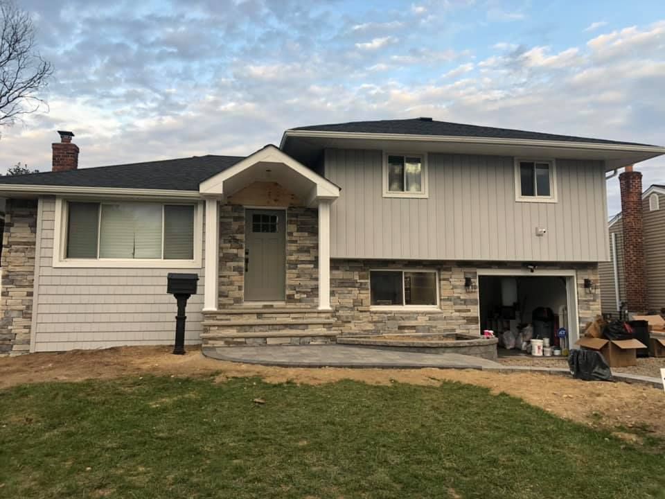 A house with a garage and a mailbox in front of it.