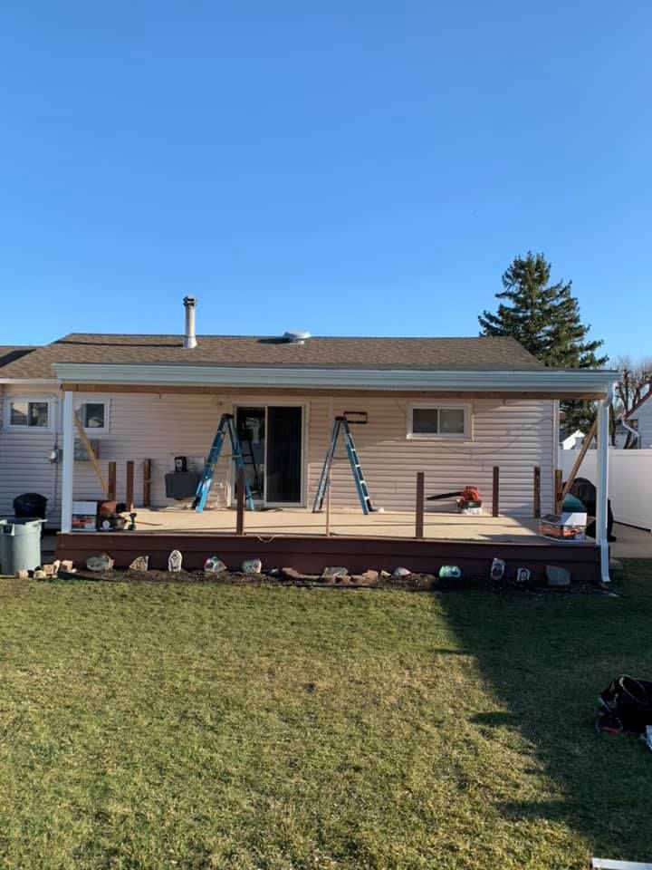 A house with a porch and a ladder in front of it.