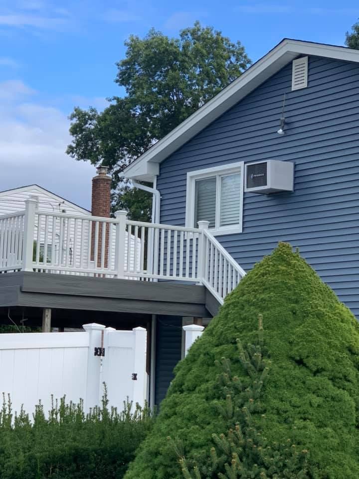 A blue house with a white deck and stairs