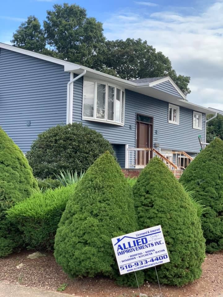 A blue house with a sign in front of it.