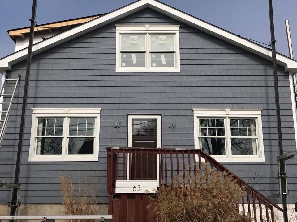 A gray house with a red deck and stairs