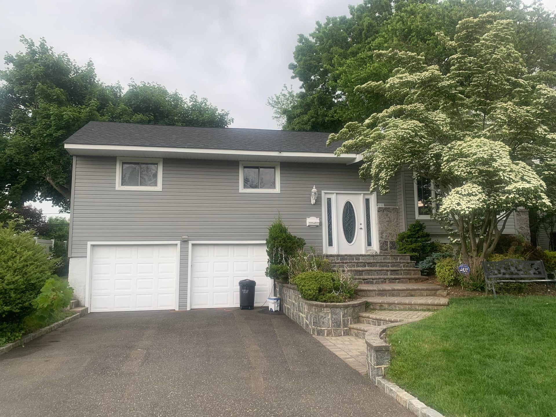 A house with two garage doors and a bench in front of it