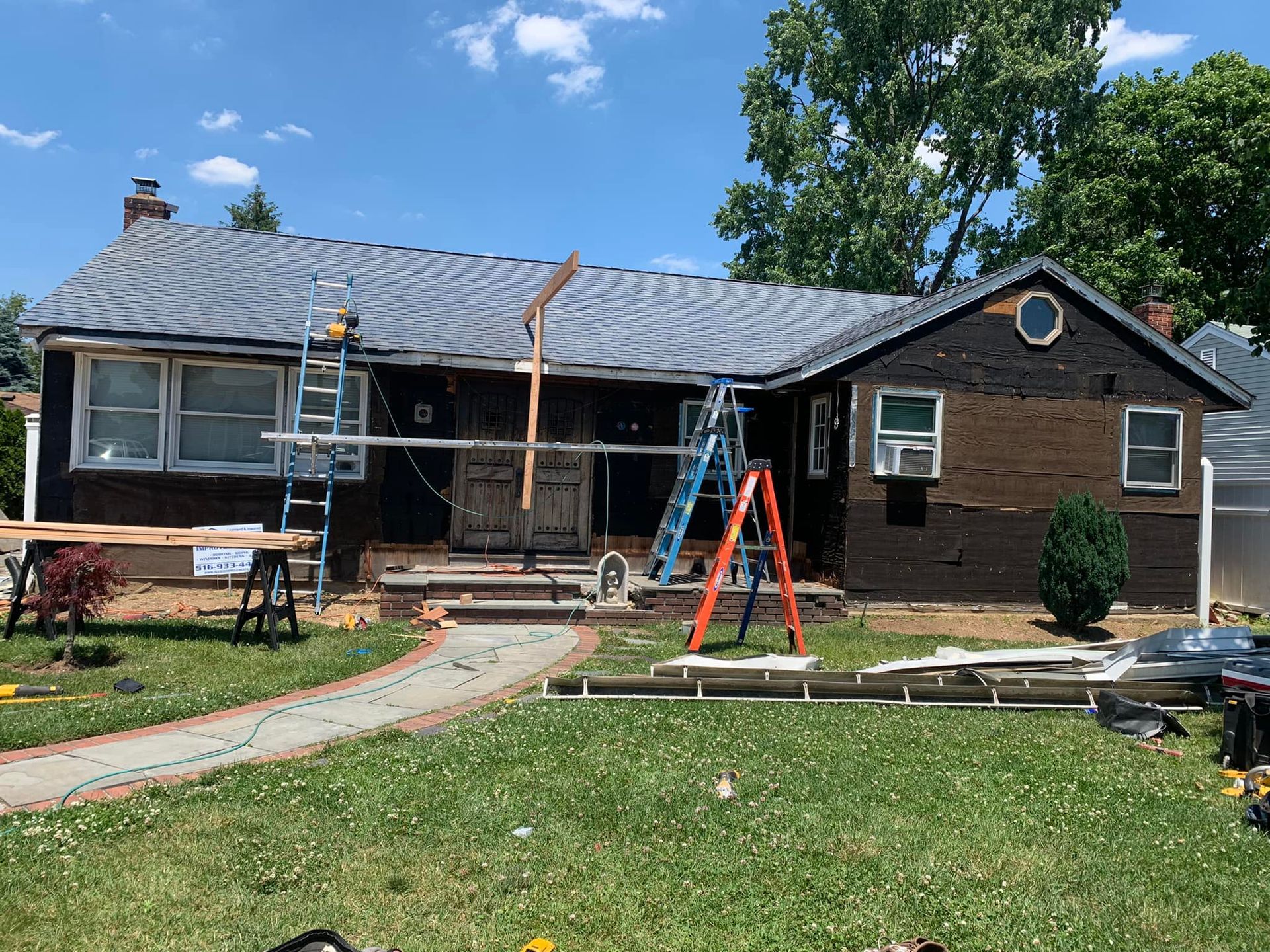 A house is being remodeled with a ladder in front of it.