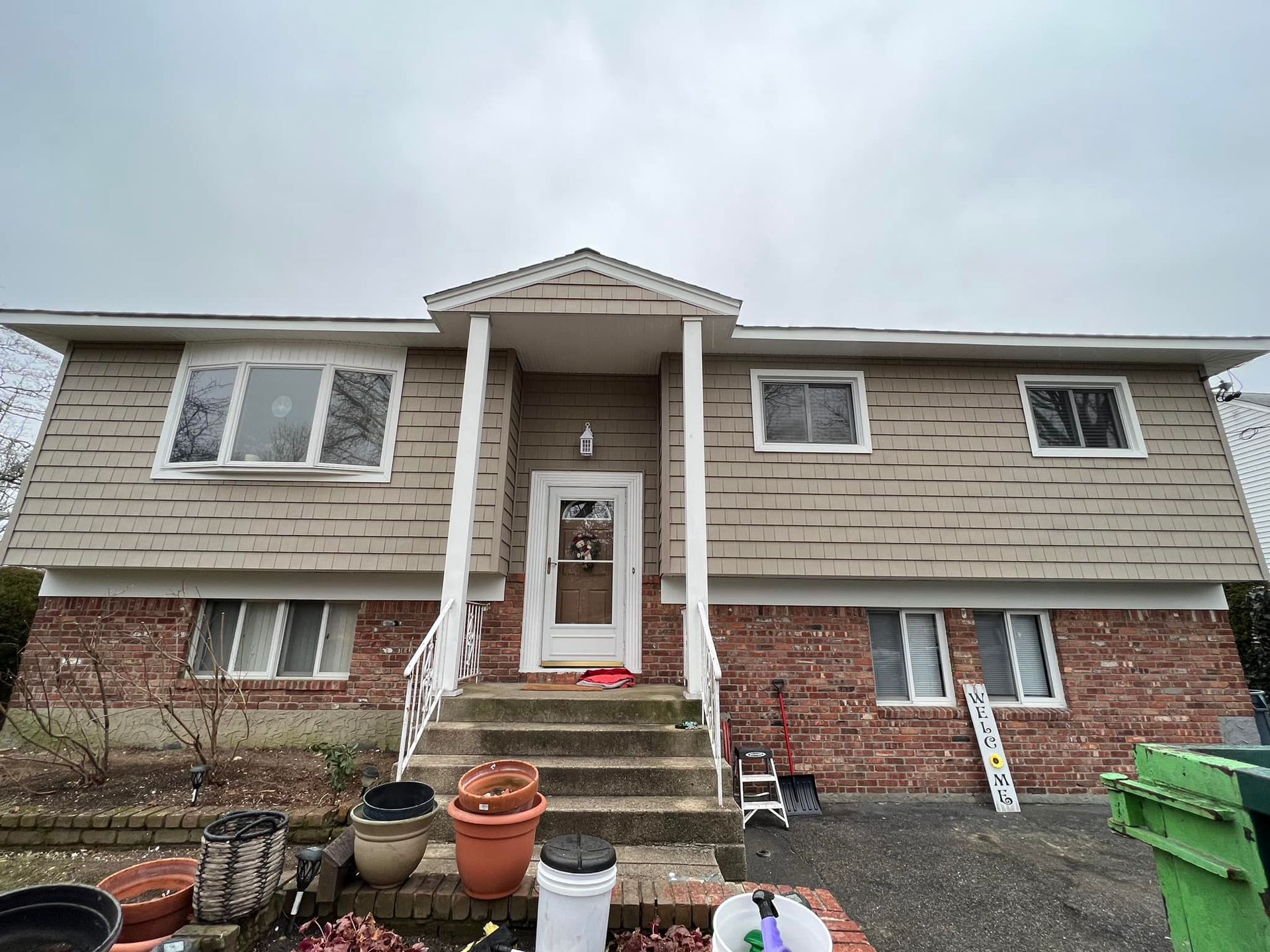 A large brick house with stairs leading up to the front door.