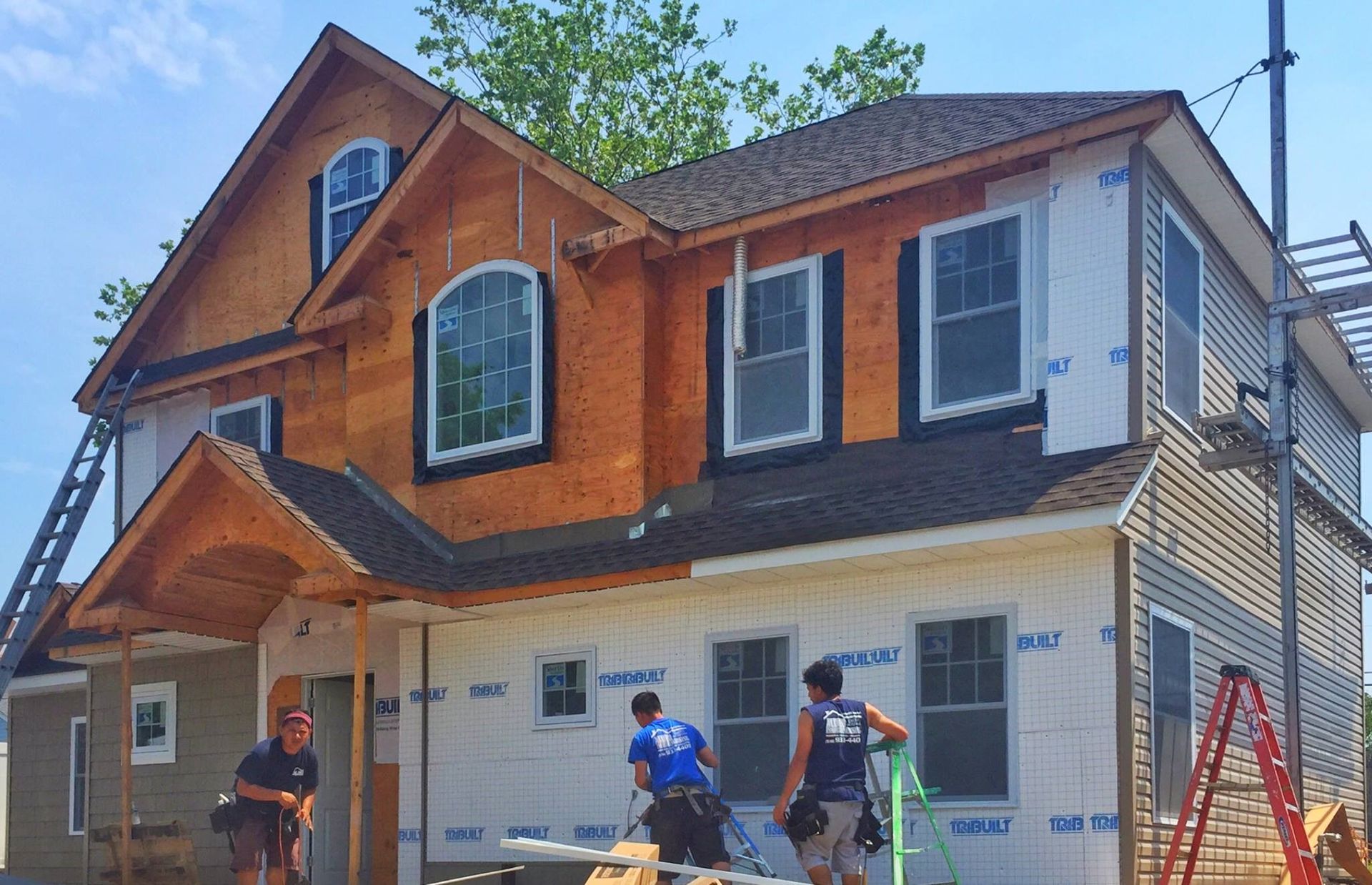 A group of men are working on a house under construction.