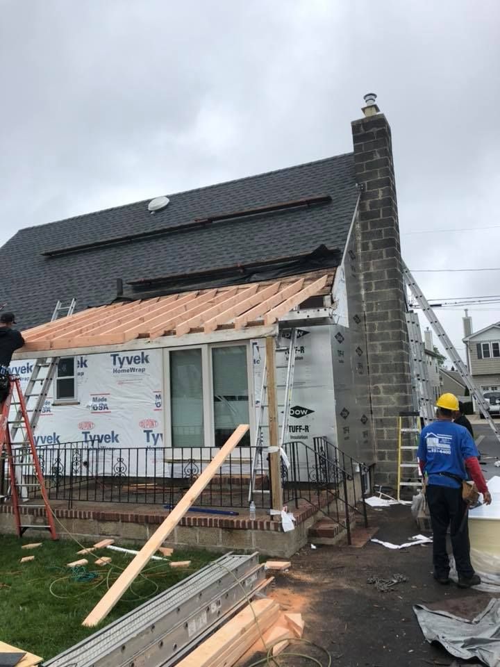 A group of people are working on a roof of a house.