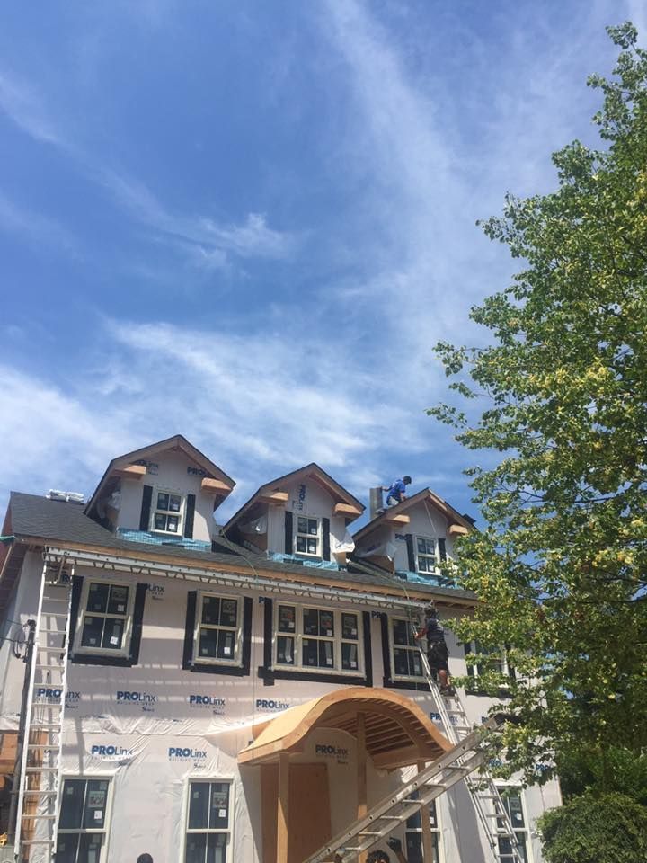 A man is working on the roof of a house.