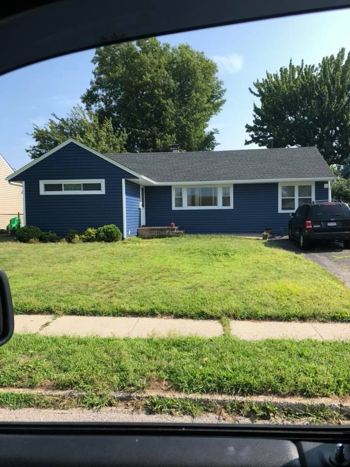 A blue house with a car parked in front of it