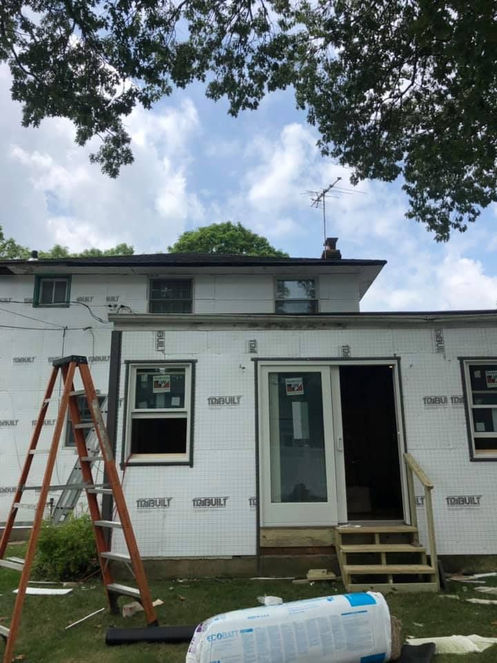 A ladder is sitting in front of a house that is being remodeled