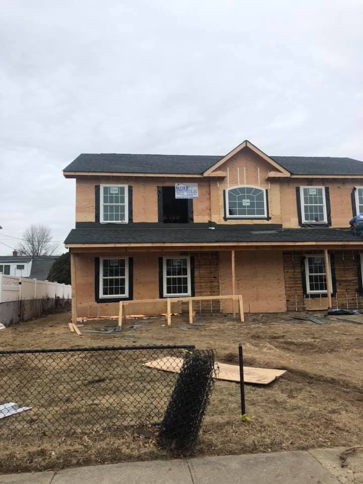 A house that is being built with a fence in front of it.