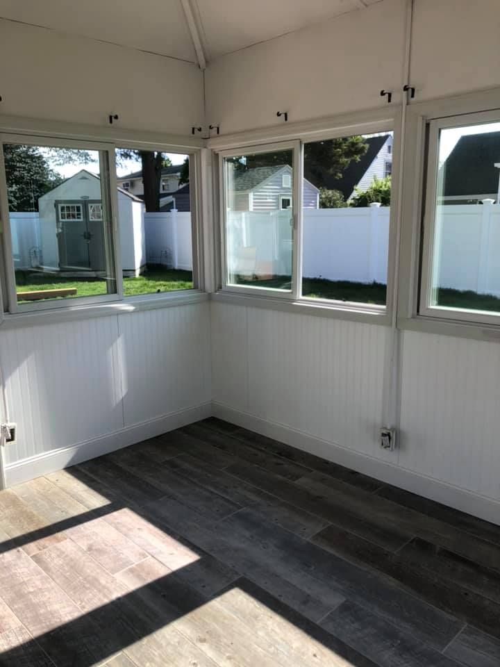 A room with a lot of windows and a wooden floor.