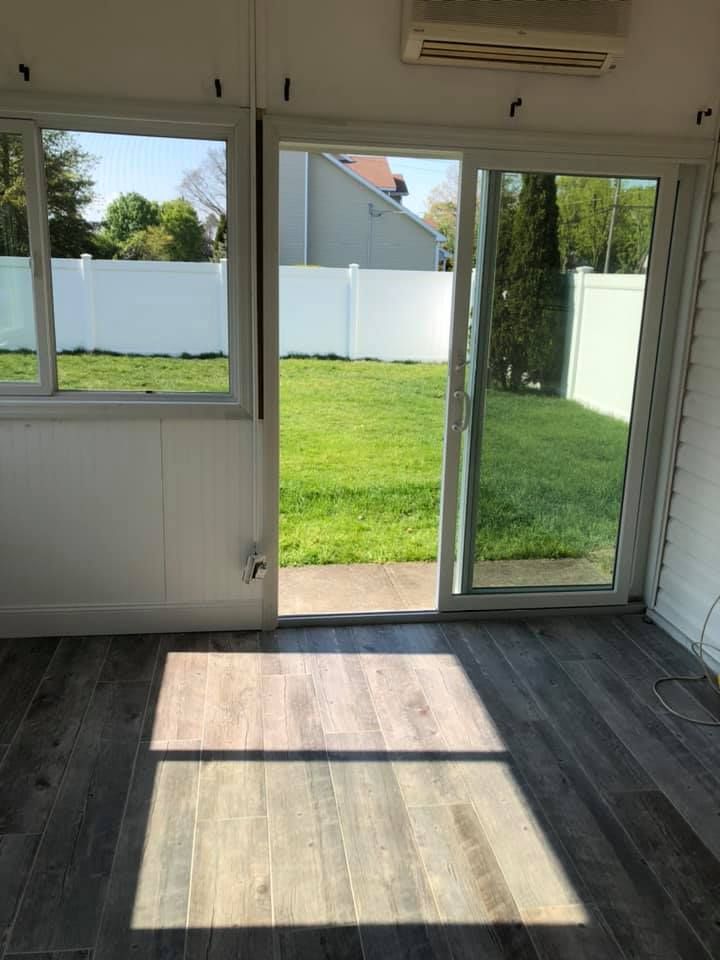 An empty room with a sliding glass door leading to a backyard.
