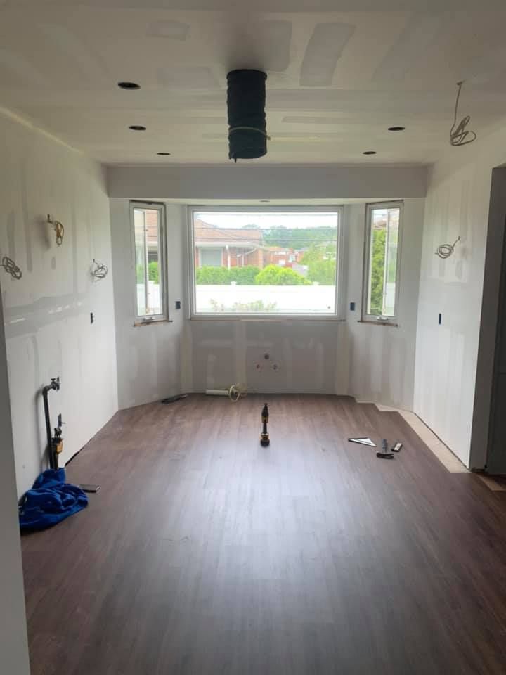 An empty room with a wooden floor and a window