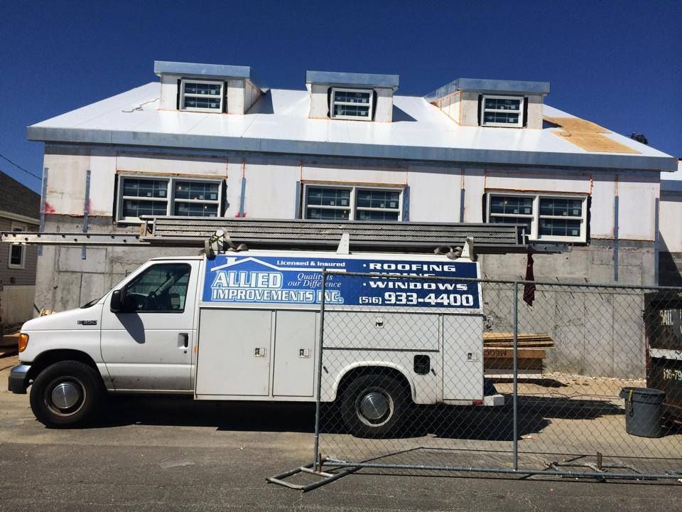 A white van is parked in front of a building that is under construction