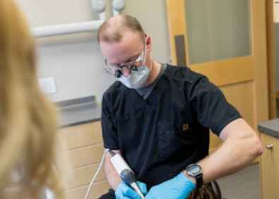 A dentist is working on a patient 's teeth in a dental office.